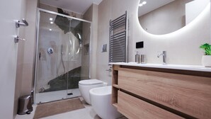 A modern bathroom with a glass shower enclosure, a wooden vanity, and a large mirror. - VivimiHome - MaisonErcolano (Ercolano)