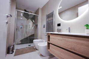 Een douche, een bidet, handdoeken, shampoo