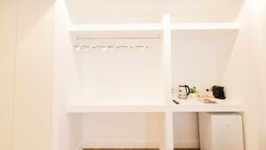 A white closet with shelves, a hanging rod, and a small white appliance. - VivimiHome - MaisonErcolano (Ercolano)