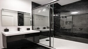 A modern bathroom with a glass-enclosed shower, a white vanity with black cabinets, and a large mirror. - Charming Cosy Studio in Saint-Denis-Stade de France (Saint-Denis)