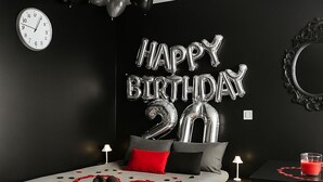 A modern bedroom with a bed, a wall clock, and a 'Happy Birthday 20' balloon decoration. - Charming Cosy Studio in Saint-Denis-Stade de France (Saint-Denis)