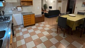 Une cuisine équipée d’une cuisinière, de placards et d’un coin repas avec une table et des chaises.