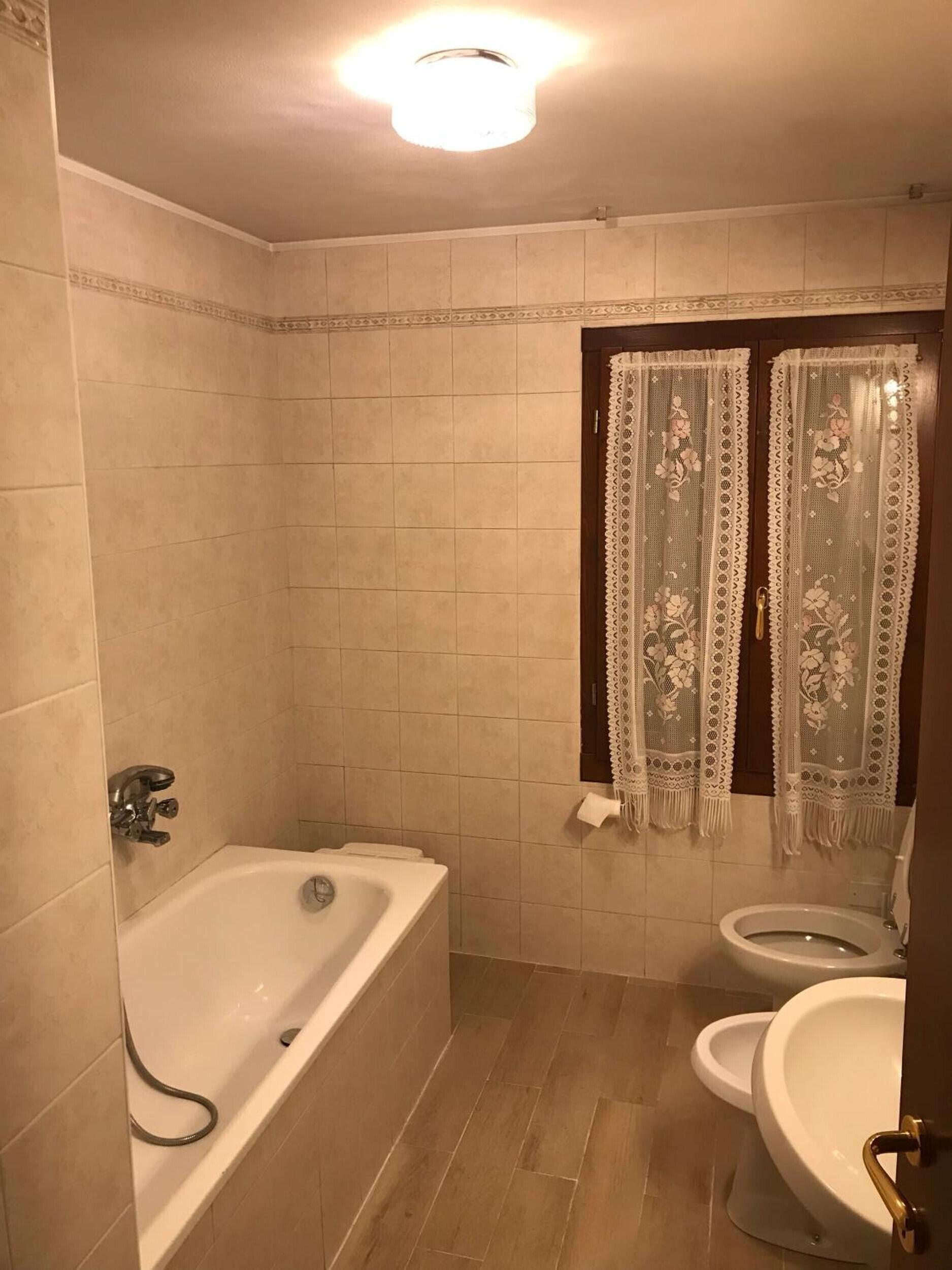 Kylpyhuone, jossa on kylpyamme, wc ja suihkuverho.