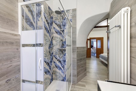 A modern bathroom with a shower, a glass door, and a wooden floor.. Apartment 'In Casetta Da Mae' with Mountain View