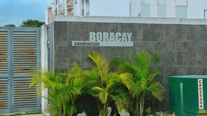 Un edificio con fachada de piedra y entrada protegida por una reja, identificado como condominio Boracay.