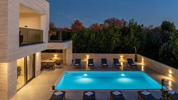 Alberca al aire libre y camastros