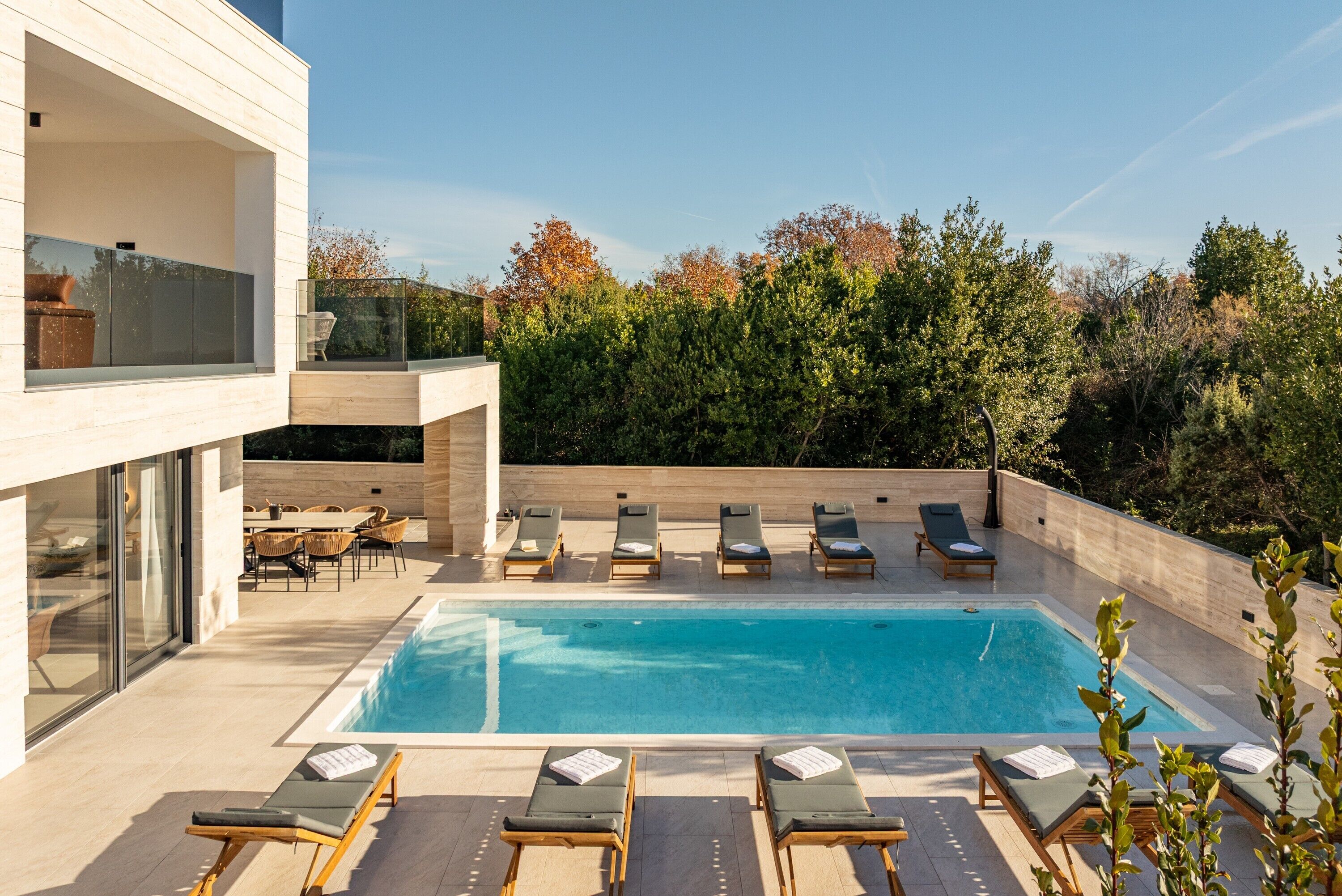 Una piscina al aire libre, sillones reclinables de piscina
