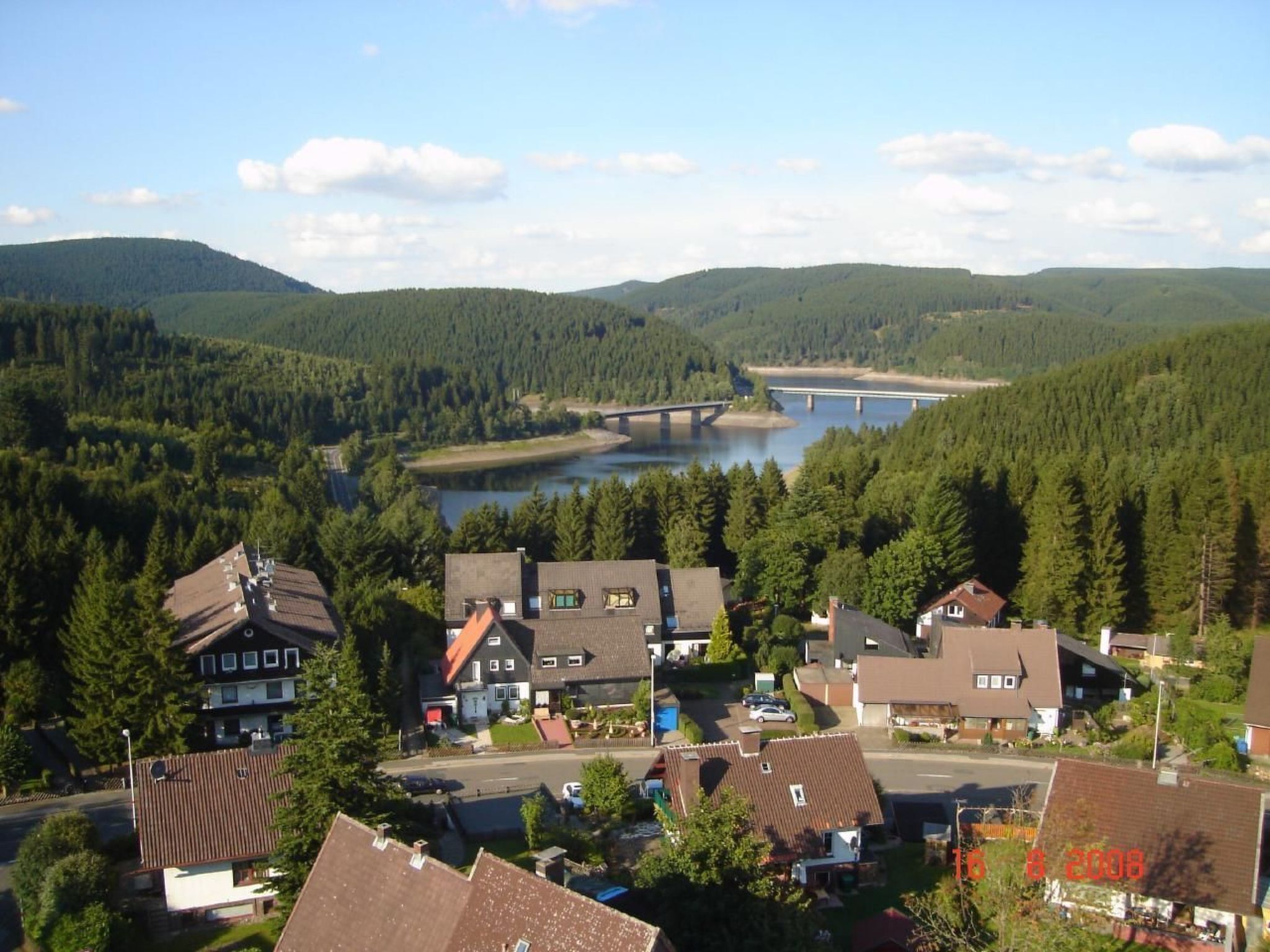 A residential area with houses, a bridge, and a river.