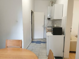 A compact kitchen with a microwave, a white refrigerator, and a small countertop.