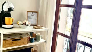 Une cuisine équipée d’une machine à café, de tasses, d’un grille-pain et d’un certificat encadré posé sur le comptoir.