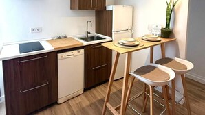 Une cuisine moderne avec des meubles en bois, un lave-vaisselle encastré et un coin repas compact avec des tabourets.