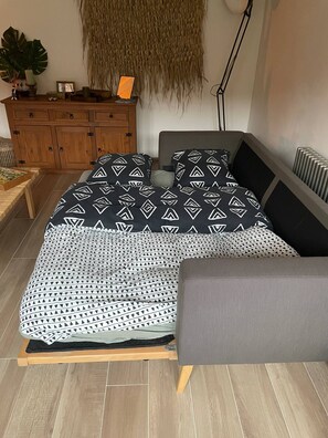 Tabla de planchar con plancha y ropa de cama