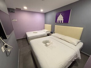 A hotel room with two beds, each with a headboard and a pillow. There is a wall-mounted TV and a painting of a building. - Grand Village Hotel  (Ampang)