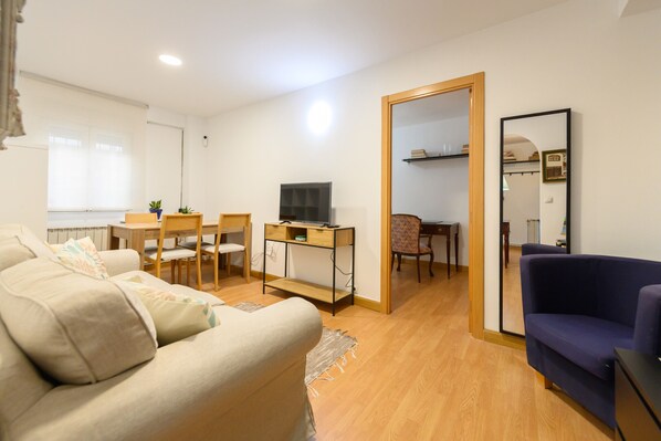 A living room with a sofa, a TV, a desk, and a chair. - Modern and functional flat with two double bedrooms in Madrid Tempory BEN28BE (Madrid)