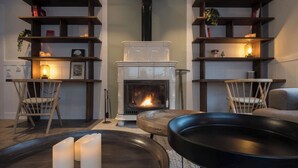 Una sala de estar acogedora con chimenea, estanterías de madera y asientos cómodos.