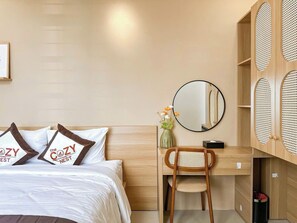 Habitación de hotel con cama, escritorio, silla, espejo y un panel de pared tejido.