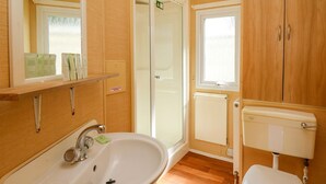 A bathroom with a sink, toilet, and shower area. - Caravan 2 at Blackmoor Farm Near Tenby (Narberth)