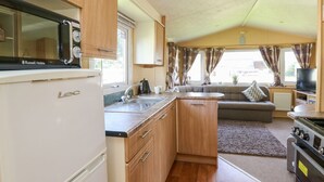 A compact RV kitchen with a refrigerator, microwave, sink, and stove. - Caravan 2 at Blackmoor Farm Near Tenby (Narberth)