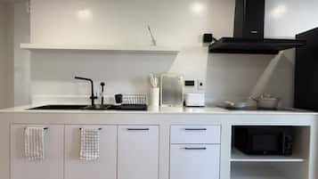 Familiekamer | Privékitchenette | Een microgolfoven, een waterkoker, schoonmaakproducten, een eettafel