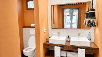 Un bagno con due lavandini, uno specchio e un appendi-asciugamani a parete.