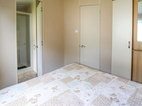 Une chambre à coucher comprenant un lit, une armoire et une porte donnant sur une salle de bain.