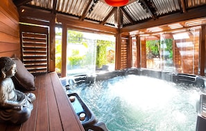 A hot tub with a wooden deck and a Buddha statue. - Famous Palm Beach Home! 120-jet Spa Cabana, Games Room & Prime Central Location! (Sydney)