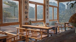 Un interior de madera con ventanas amplias, mobiliario de madera y caligrafía china en las paredes.