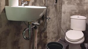Un baño con lavamanos blanco, inodoro y ducha.
