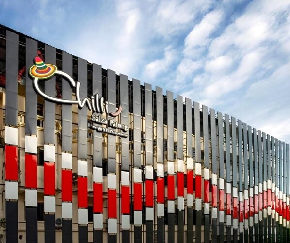A modern building with a distinctive facade featuring vertical panels in red, white, and gray. - Chilli House Patong (Patong)