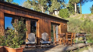 A rustic wooden cabin with a porch, outdoor seating, and a barbecue grill. - Agriturismo Polgara (Casciana Terme Lari)