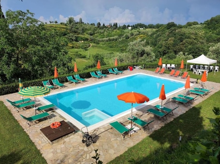 Una piscina al aire libre de temporada, sombrillas