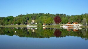 A calm lake with a reflection of a building and trees.