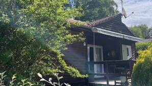 A rustic wooden house with a sloped roof, a satellite dish, and a number '24' sign.