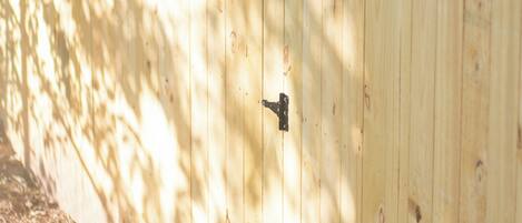 A wooden fence with a metal latch.