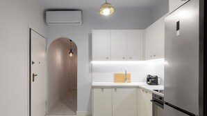 A modern kitchen with white cabinets, a built-in oven, and a coffee maker. - Valerie by halu (Thessaloniki)