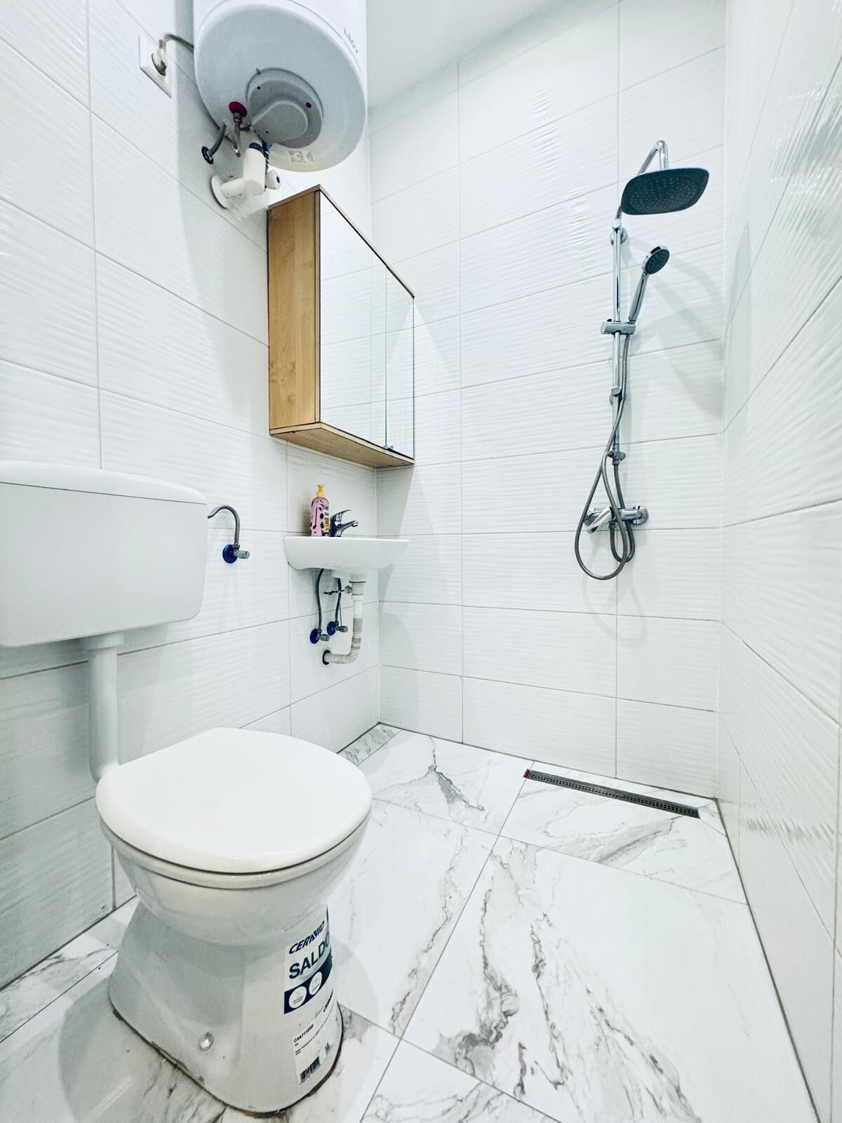 Un baño moderno con inodoro, lavabo y ducha.
