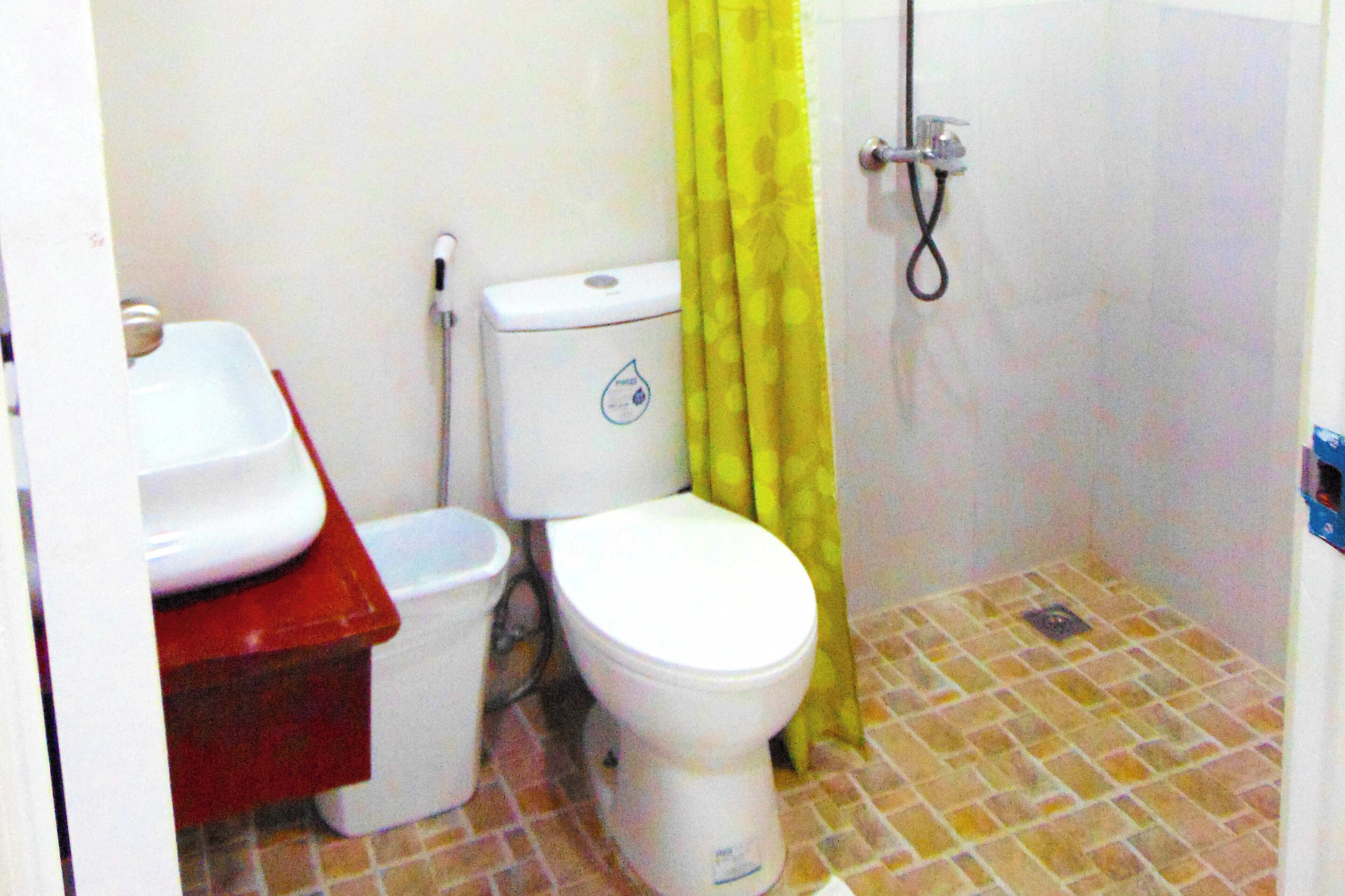 Un baño pequeño con inodoro, lavabo y ducha.
