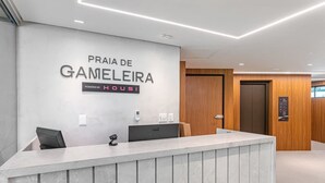 Un comptoir d'accueil avec une pancarte indiquant « Praia de Gameleira » et « En partenariat avec Housi ».