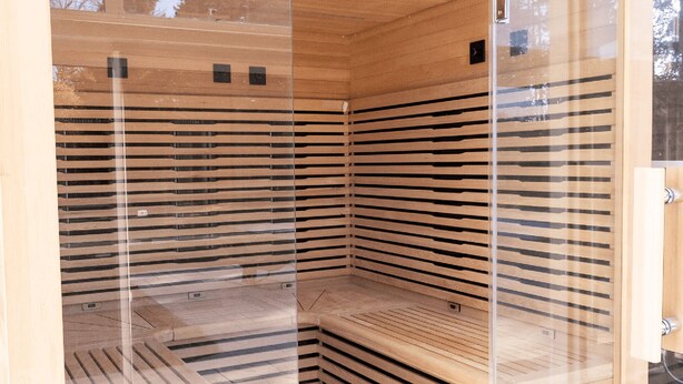 A sauna with a wooden interior and glass walls.