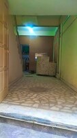 Un pasillo con suelo de baldosas, una escalera y una puerta a la izquierda.