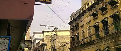 A street view with a building labeled "HOTEL PRIME" and a motorcycle parked on the street.