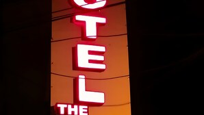 A vertical neon sign with the words "HOTEL THE PRIME" in bright red and yellow colors. - Hotel The Prime (Rawalpindi)