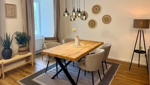 En spiseplads med et træbord, fire stole, en bænk og en potteplante.