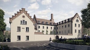 En moderne bygning med en symmetrisk facade, mange vinduer og en central skorsten.
