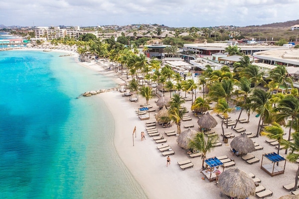 On the beach, white sand, beach cabanas, sun loungers