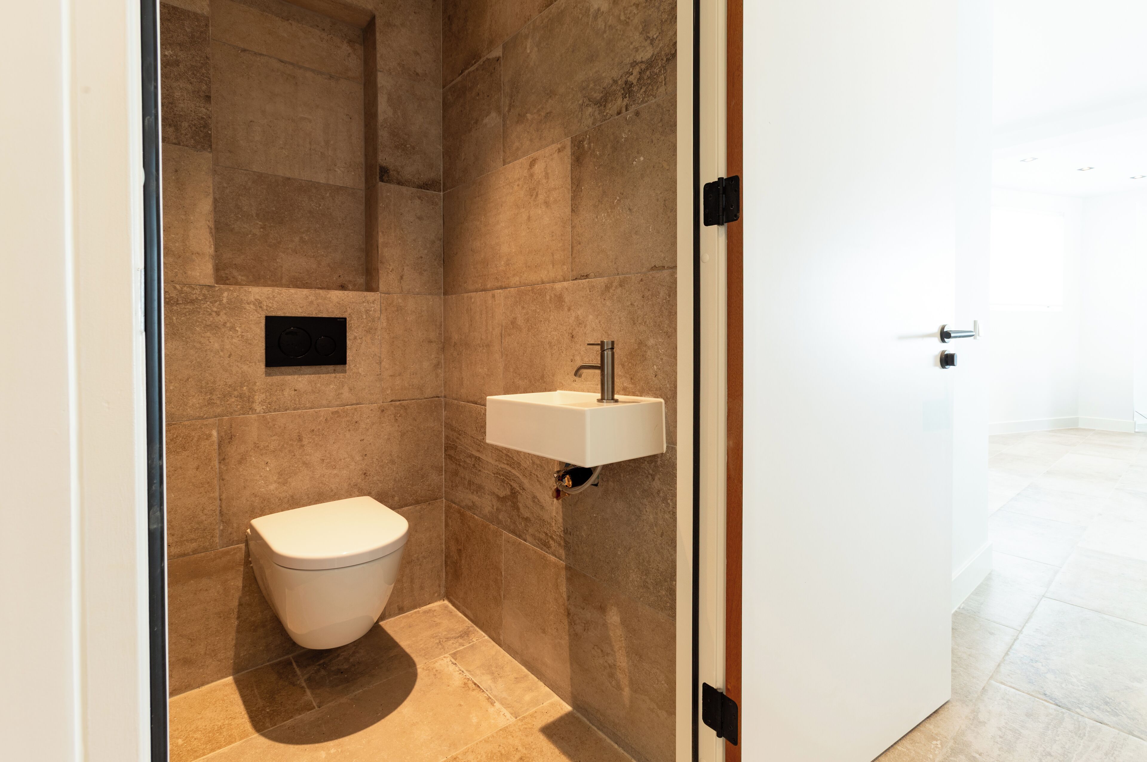 A modern bathroom with a toilet, a sink, and a shower area.