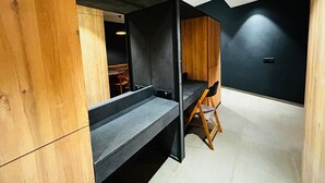 A modern room with a wooden desk, a chair, and a dark wall.