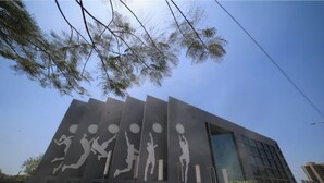 A modern building with a unique facade featuring large white silhouettes of basketball players in various poses.