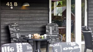 A patio area with two chairs and a table, a lamp, and a sign with words like "relax" and "life." - VillaVilla 171 - Ebeltoft, Østjylland (Ebeltoft)