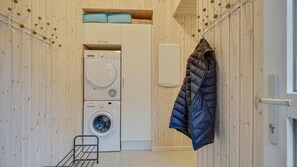 A laundry room with a washing machine and dryer, a coat rack, and a metal drying rack. - VillaVilla 472 - Grenå Strand, Østjylland (Grenaa)
